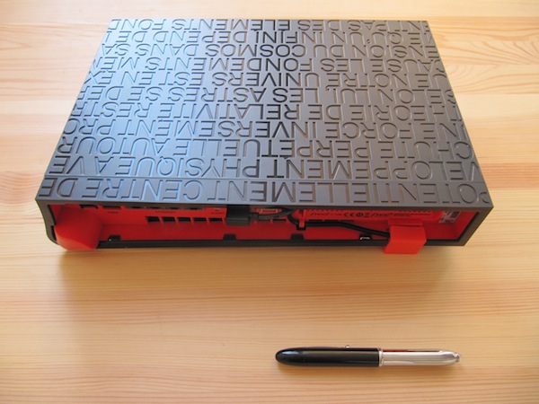 Back-down view of the Freebox Server, with a pen for scale