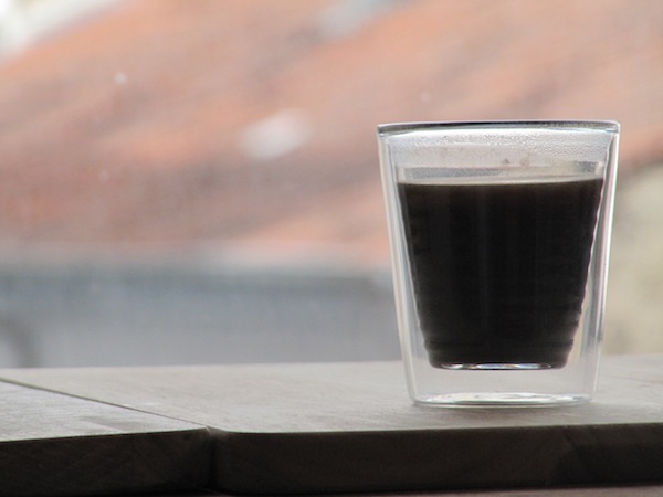 A shot of coffee in a double walled glass.