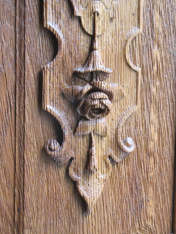 The cathedral doors are carved wood with a strong grain.