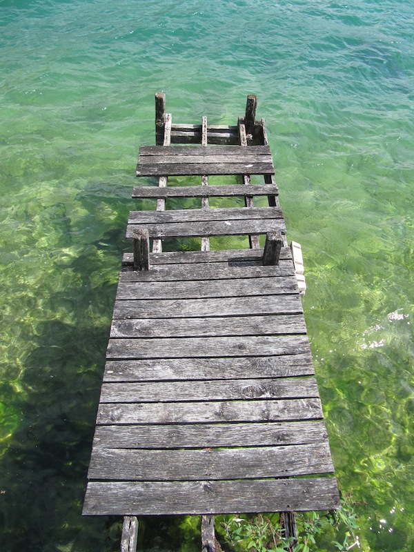 A decaying jetty hovers over the water of Lake Annecy.