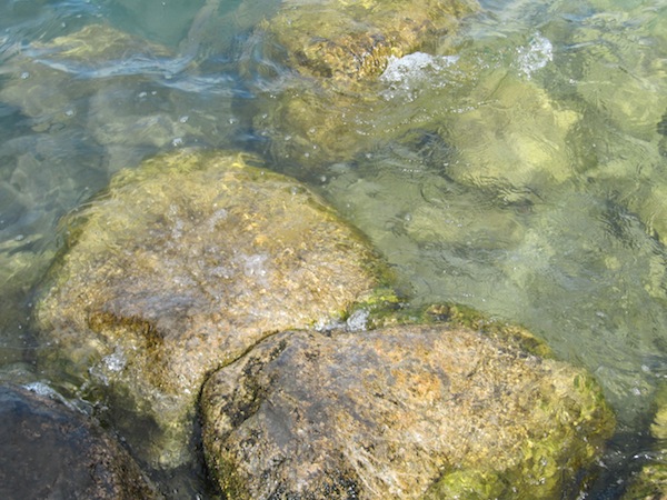 Rocks lapped by water line much of the lake.