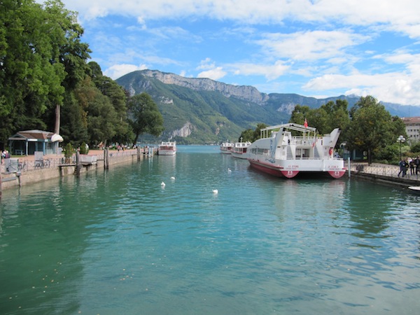 A tourist boat waits for customers where Lake Annecy meets Annecy town.