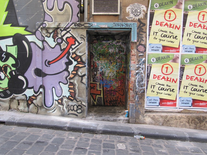 A recessed doorway in a lane of graffiti covered walls