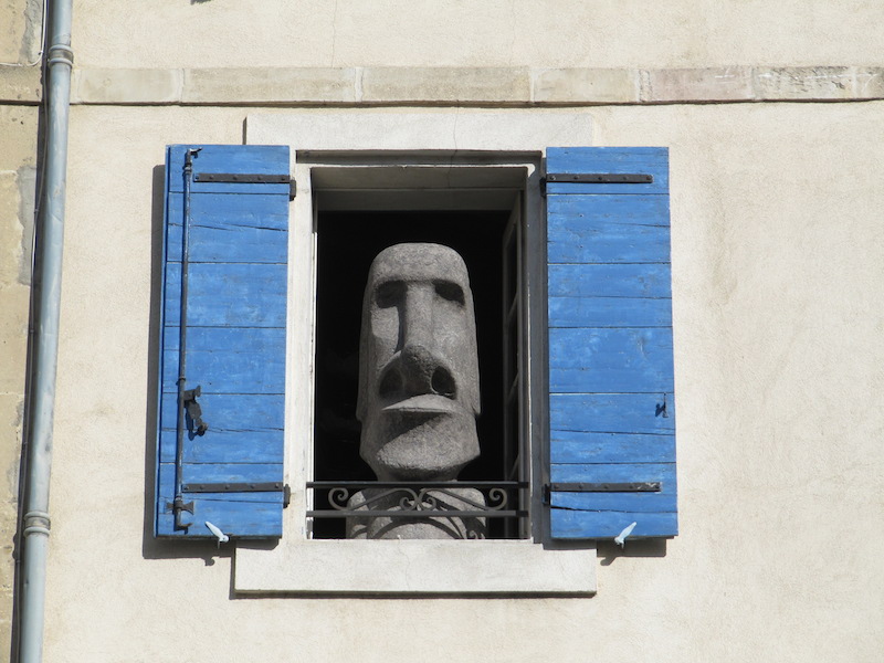 Easter Island statue replica looking out of a window