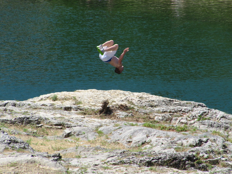 Young man jumping into the water below