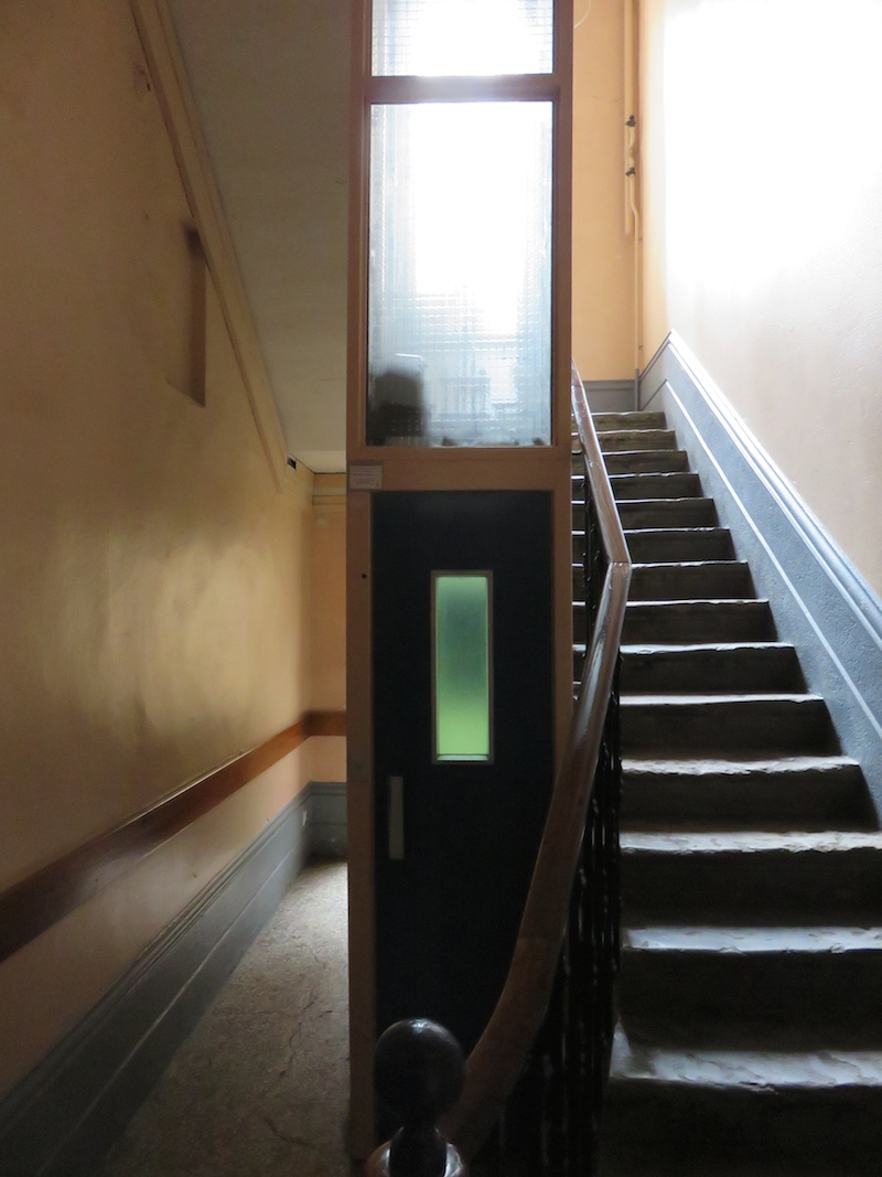A tiny elevator encroaching on the stairs