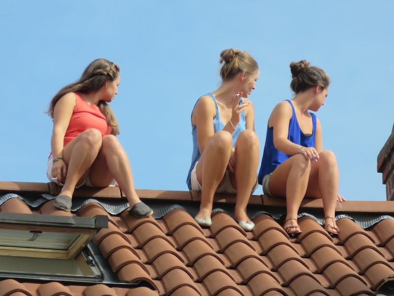 Girls sitting on a rooftop smoking