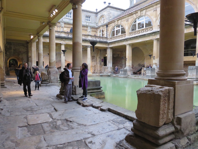 Tourists walk around the baths