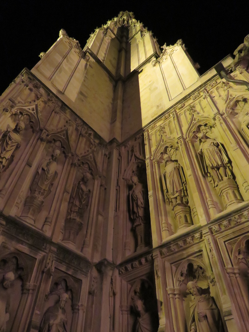 Looking up at Canterbury cathedral at night.