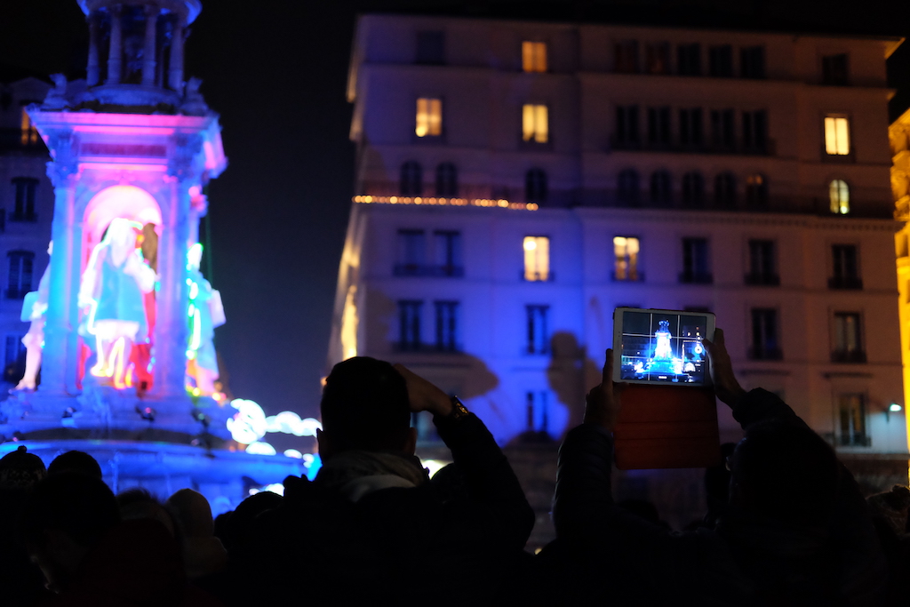 A man photographs the illumination at Place des Jacobins in Lyon.