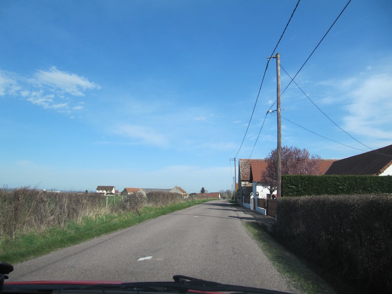 A photograph of a quiet country road in Allier, France